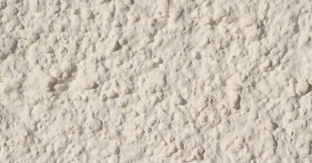 Close-up of rough textured white stucco surface