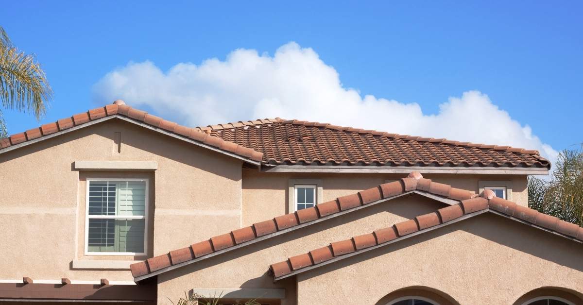 Stucco exterior walls with red tile roof and window