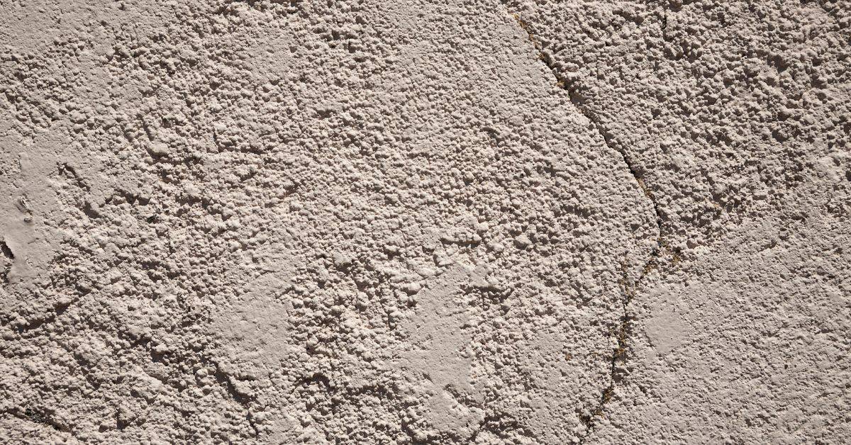close up of beige stucco wall with visible crack