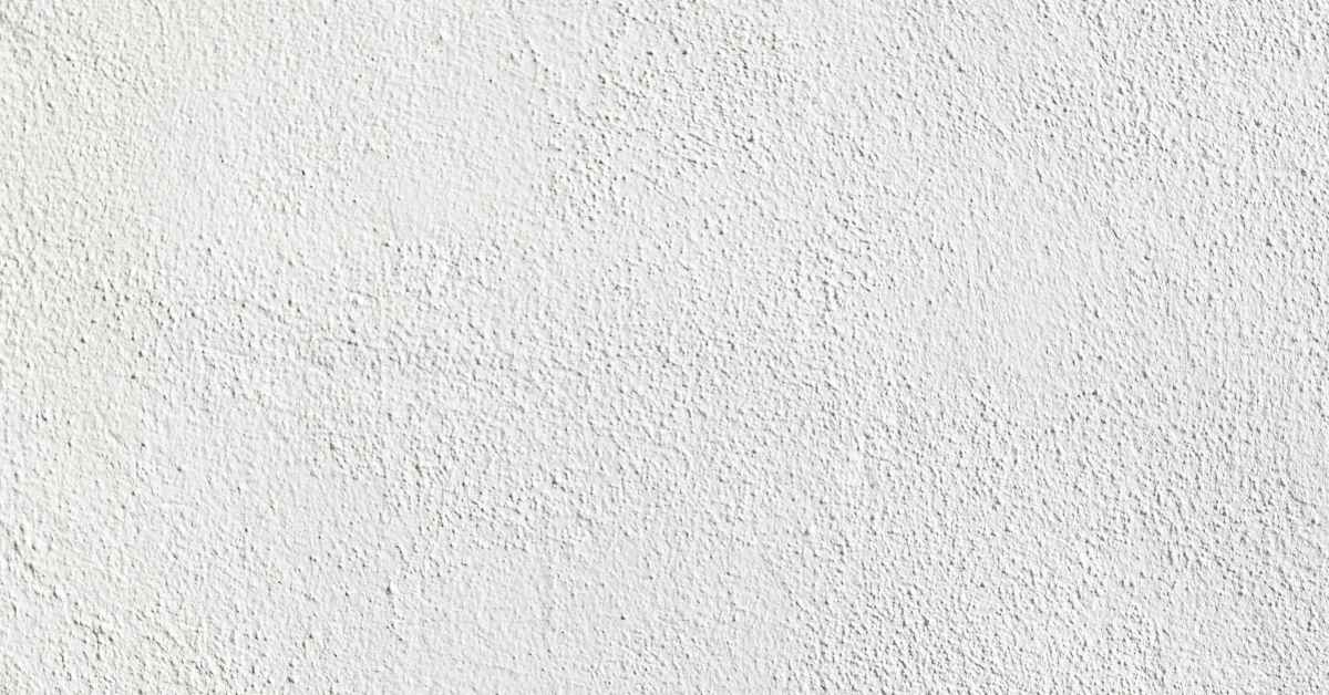 Close-up of white textured acrylic-modified stucco surface