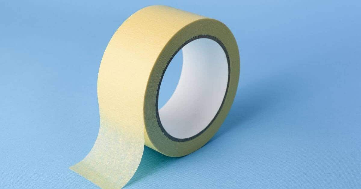 Roll of yellow painter’s tape on blue background