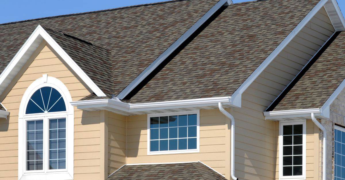 Roof with asphalt shingles and beige siding walls with windows