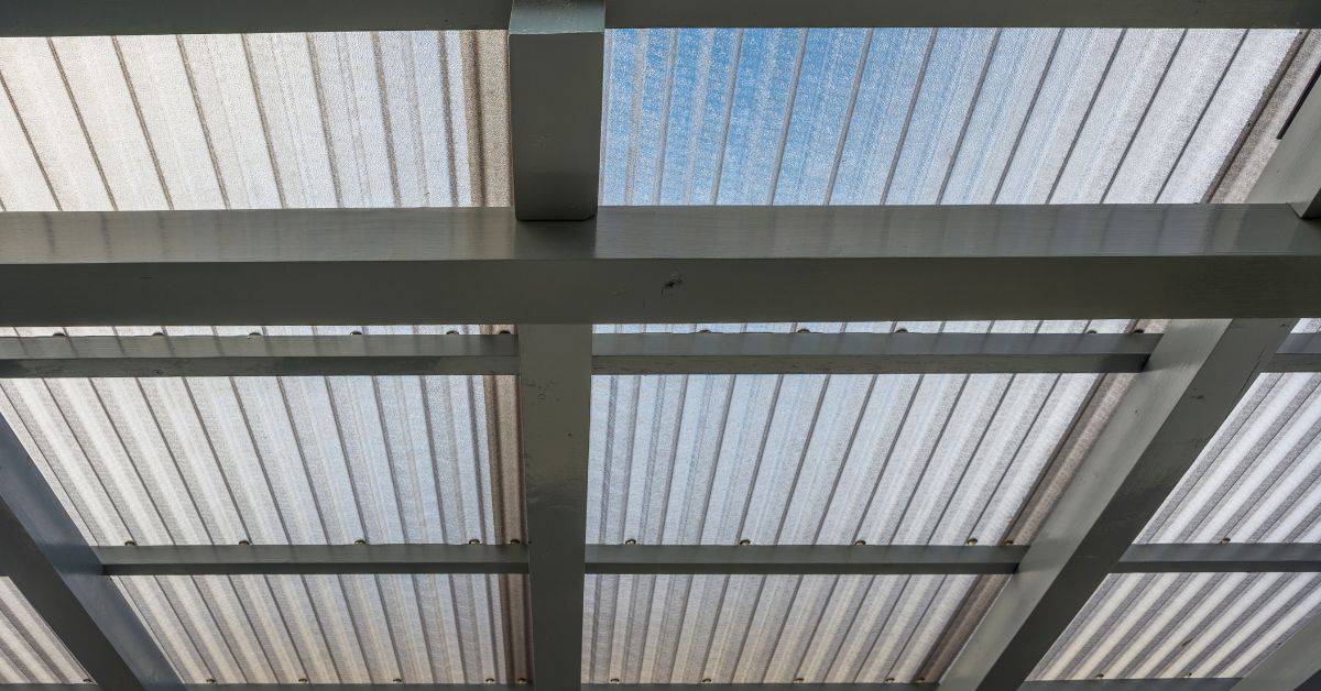 Corrugated translucent roofing panels supported by metal framework