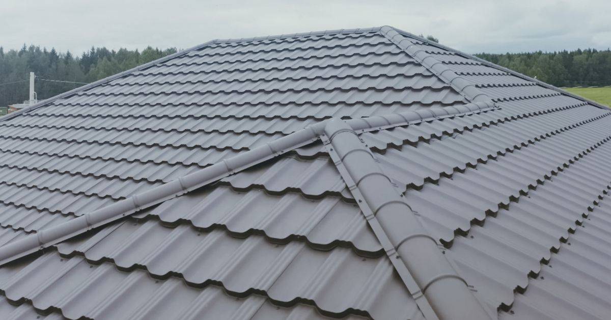Metal roof tiles with ridge cap on house roof