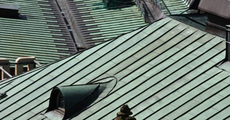 Green metal roofing panels with standing seams and vents