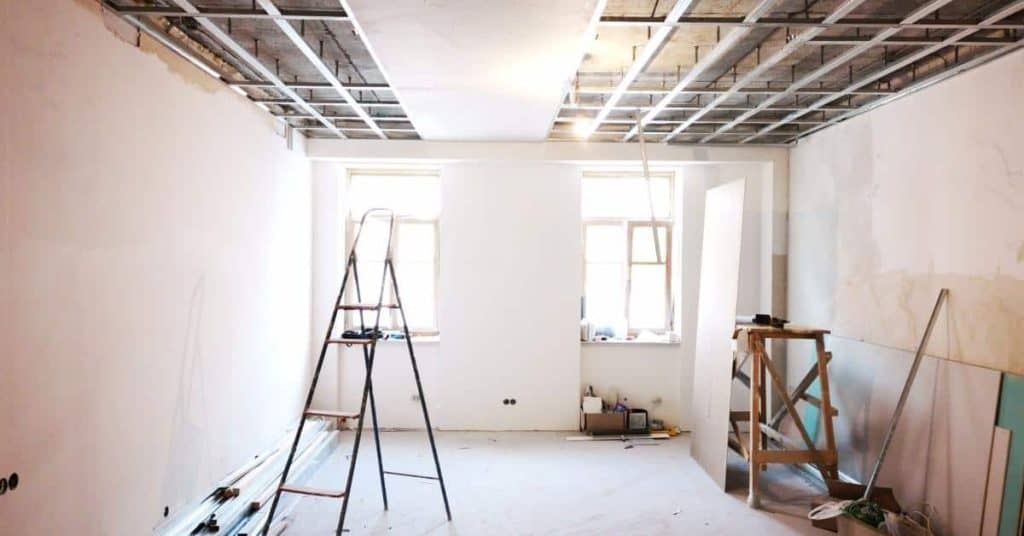 Room with exposed grid frame ceiling and ladder