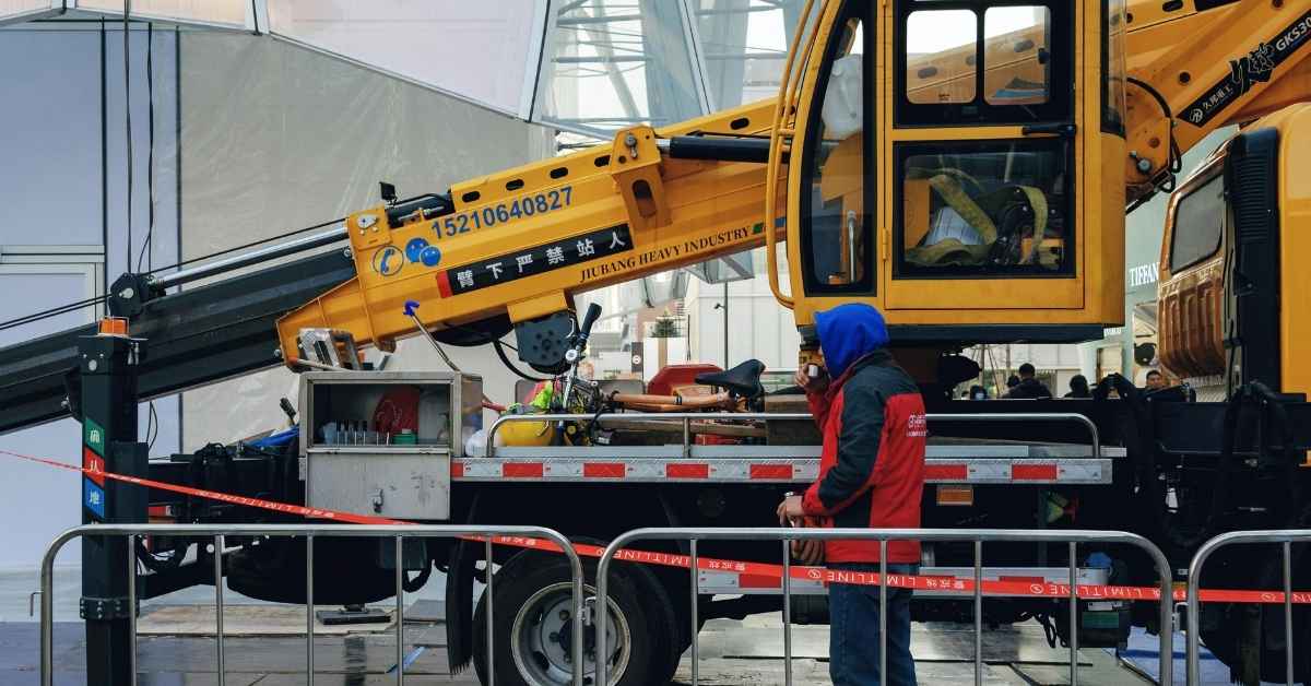 construction crane with safety barriers and worker in blue hood