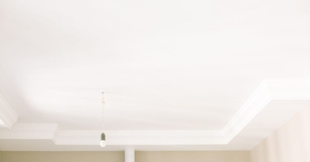 Smooth white ceiling with light fixture hanging down
