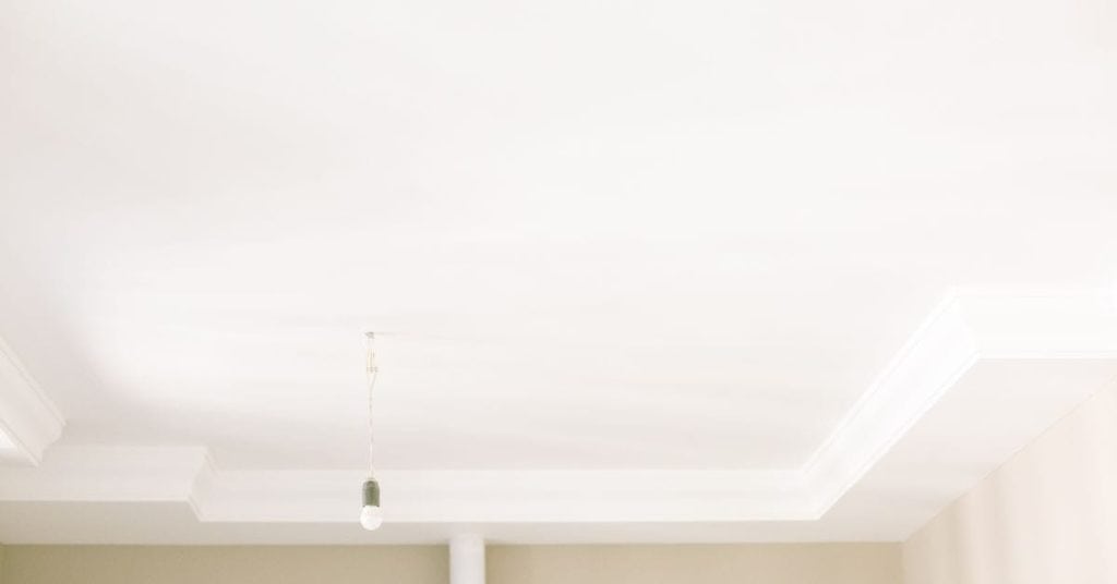 Smooth white ceiling with recessed lighting fixture hanging