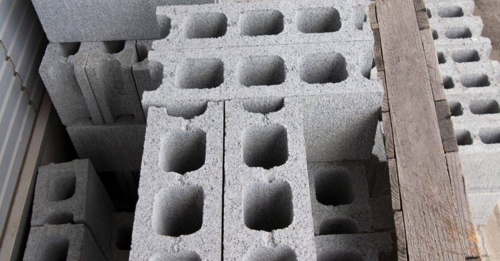 Stacked gray concrete cinder blocks with hollow centers