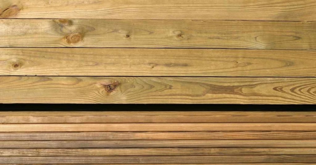 Stacked pressure-treated wood boards with visible grain patterns