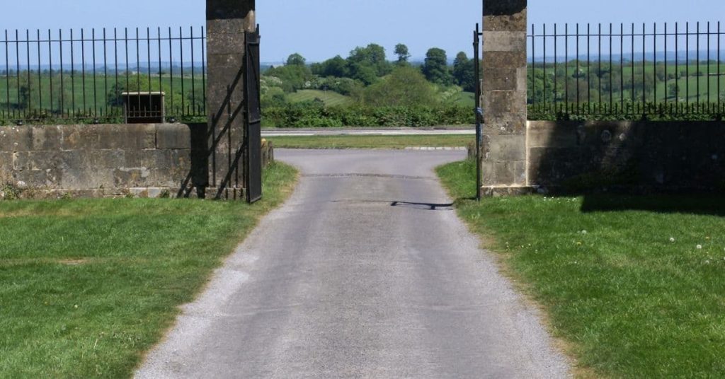 Stone-look concrete gate pillars with metal fence panels