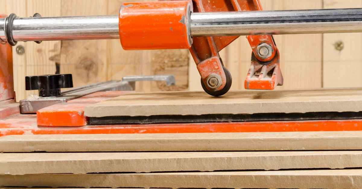 Closeup of manual tile cutter cutting stacked tiles