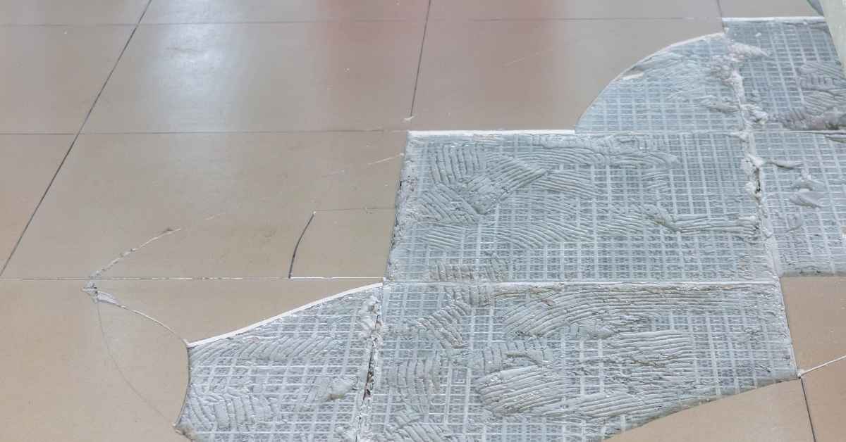 Section of floor tiles with adhesive residue exposed