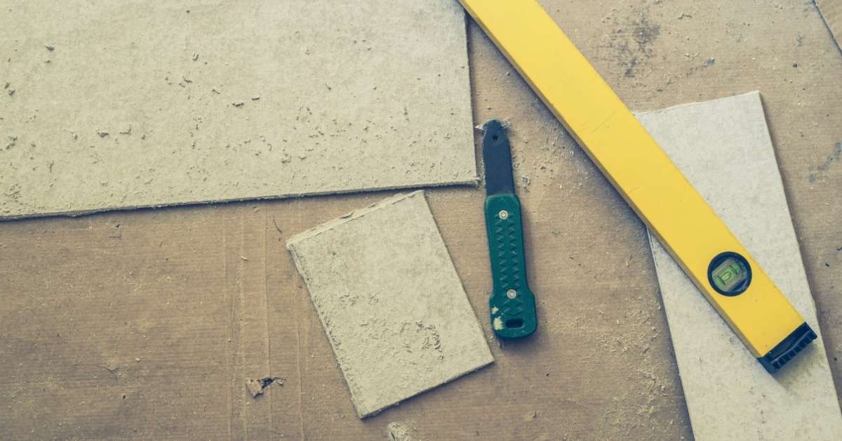 Utility knife level and cement board pieces on floor