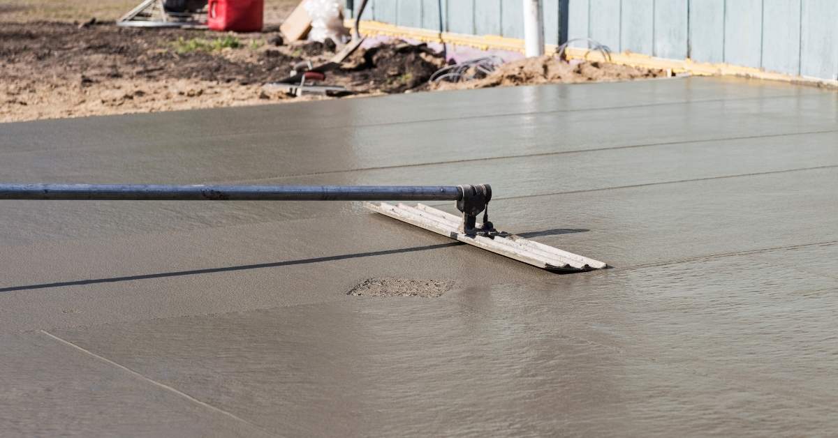 Concrete float tool smoothing freshly poured concrete slab