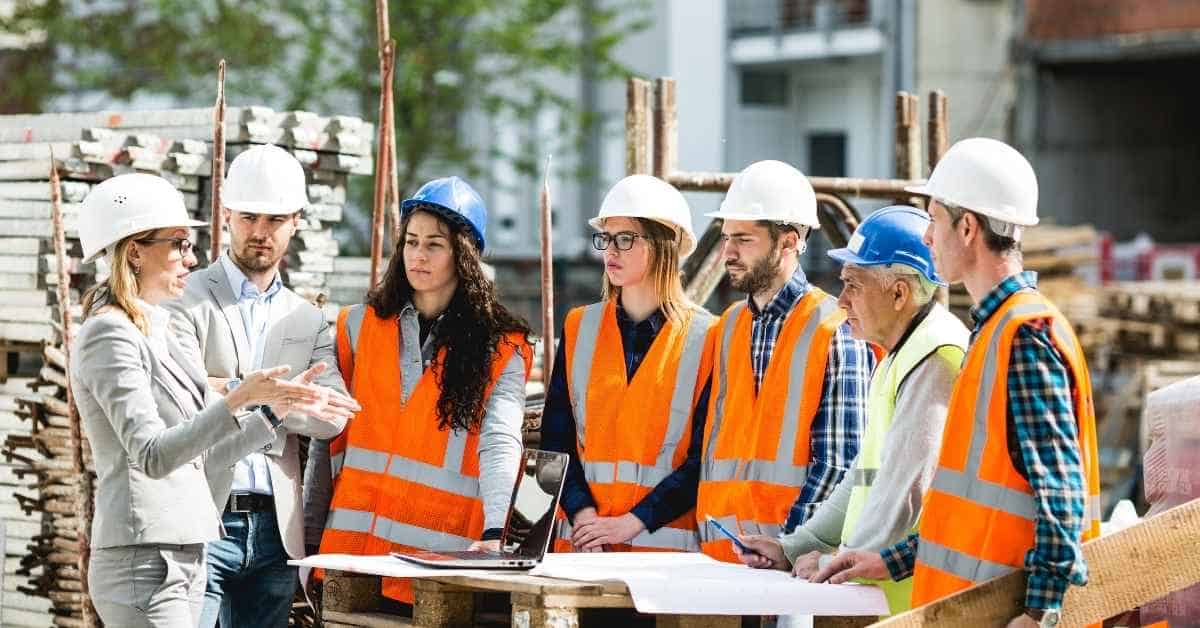 Group of construction workers in hard hats and orange safety vests