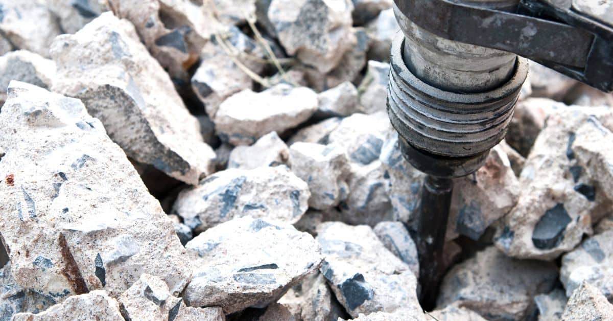 Close up of demolition hammer breaking concrete chunks