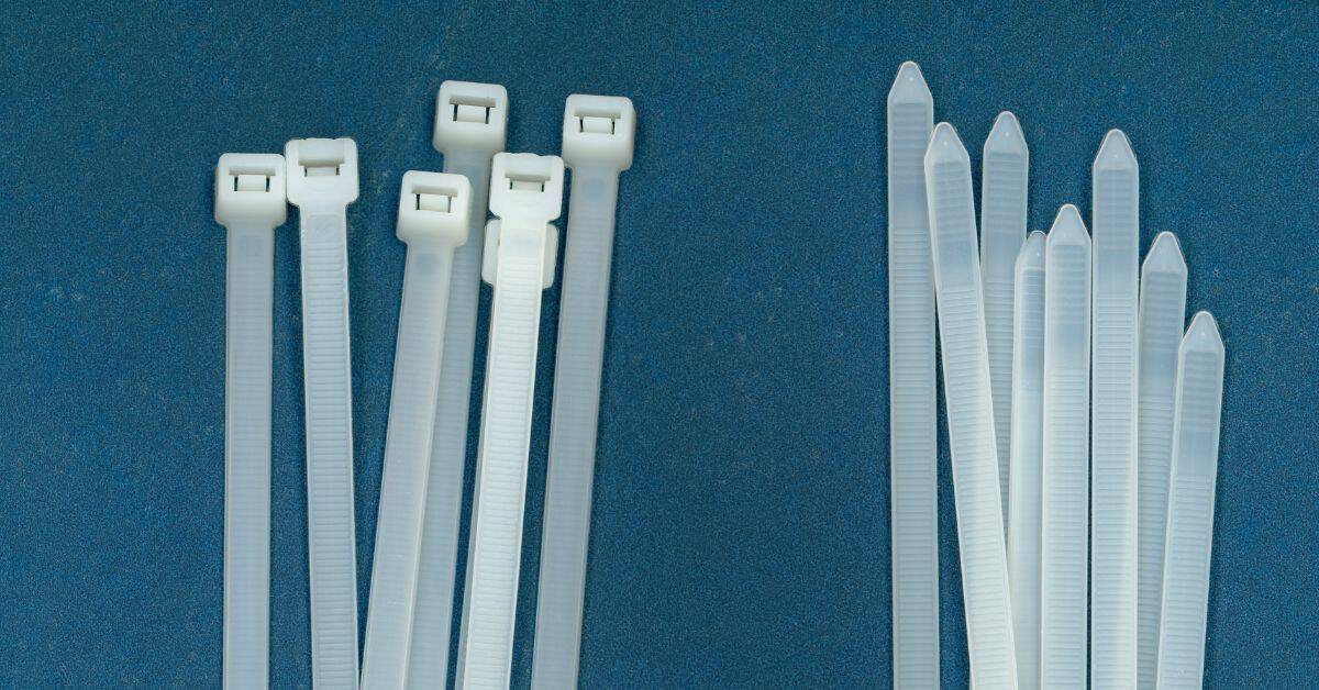 Two clusters of translucent white plastic zip ties on blue background