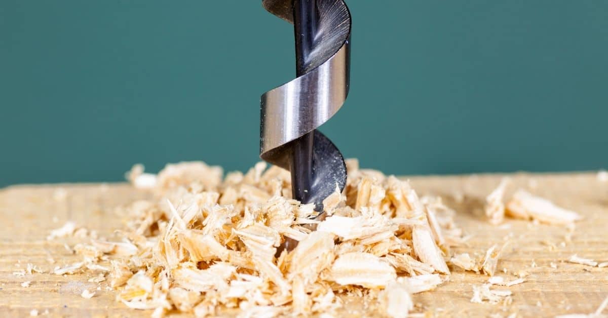 Close-up of drill bit boring into wood with wood shavings