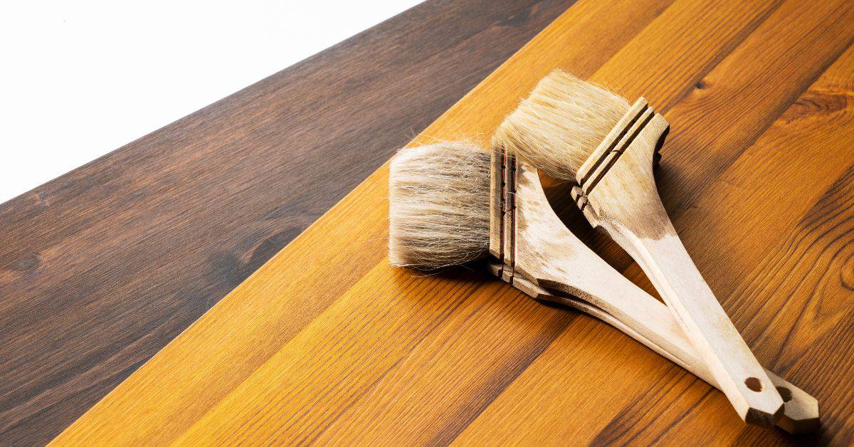 Two natural bristle brushes on stained wooden boards
