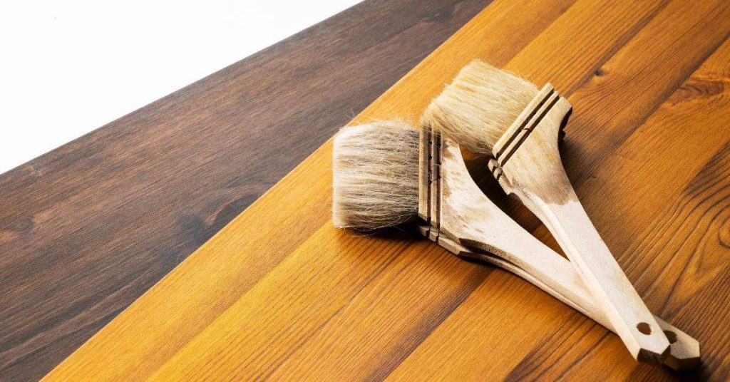 Two clean paint brushes resting on wood boards