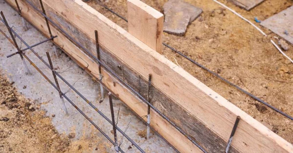 Wooden concrete form reinforced with rebar on dirt ground