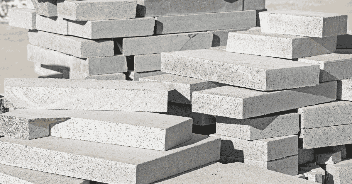 Stacks of rectangular concrete cap blocks piled outdoors
