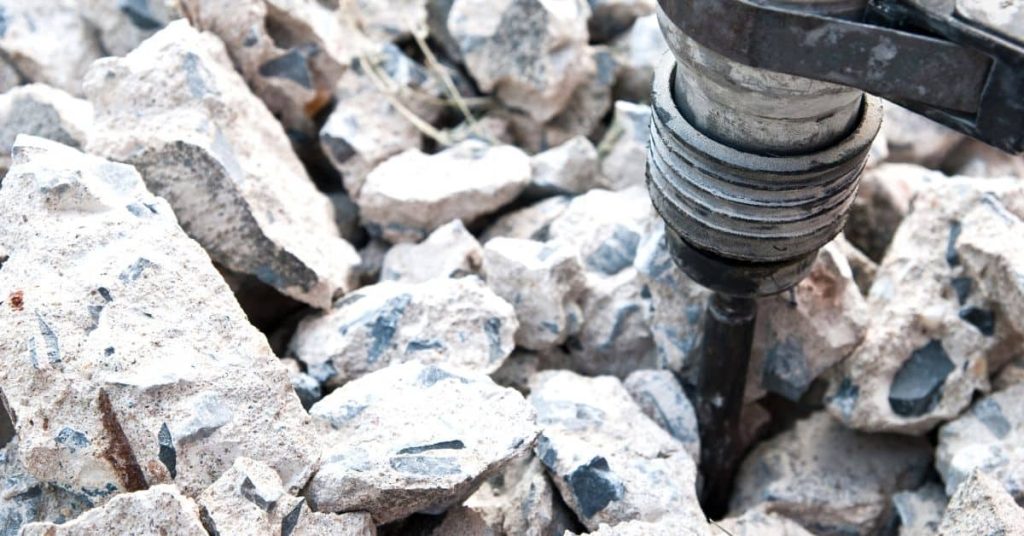 Close-up of hammer drill breaking concrete into pieces