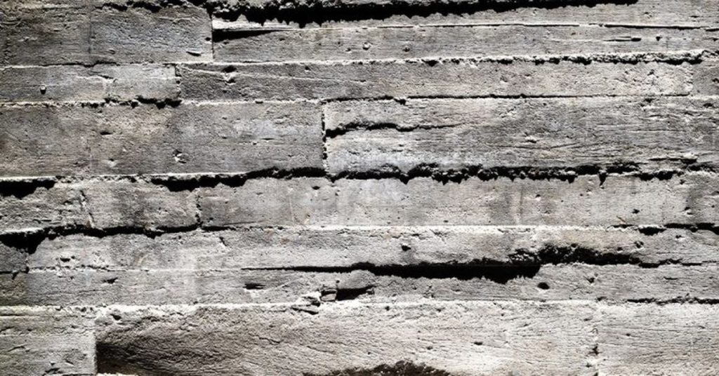 Close-up of rough concrete surface with wood grain texture