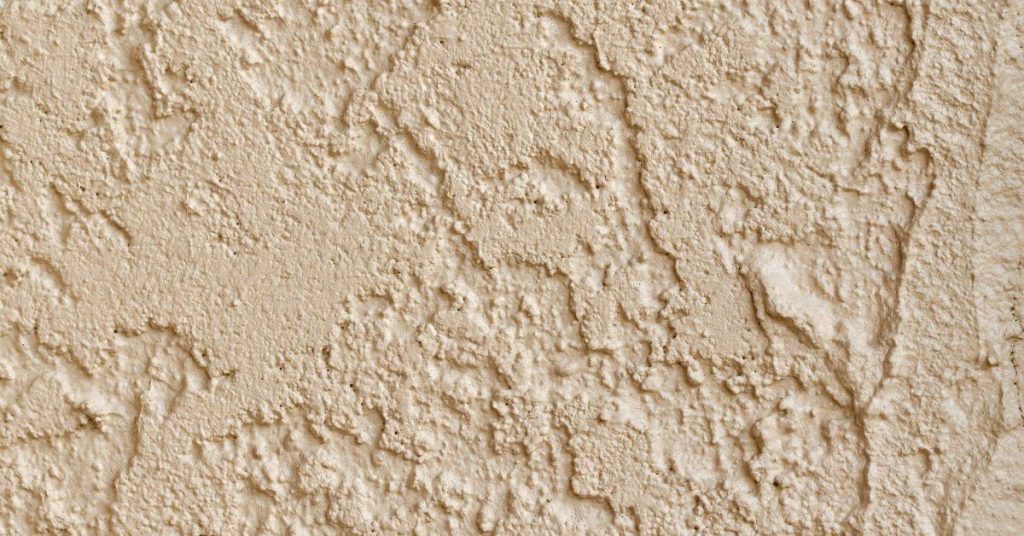 Closeup of beige textured stucco wall surface