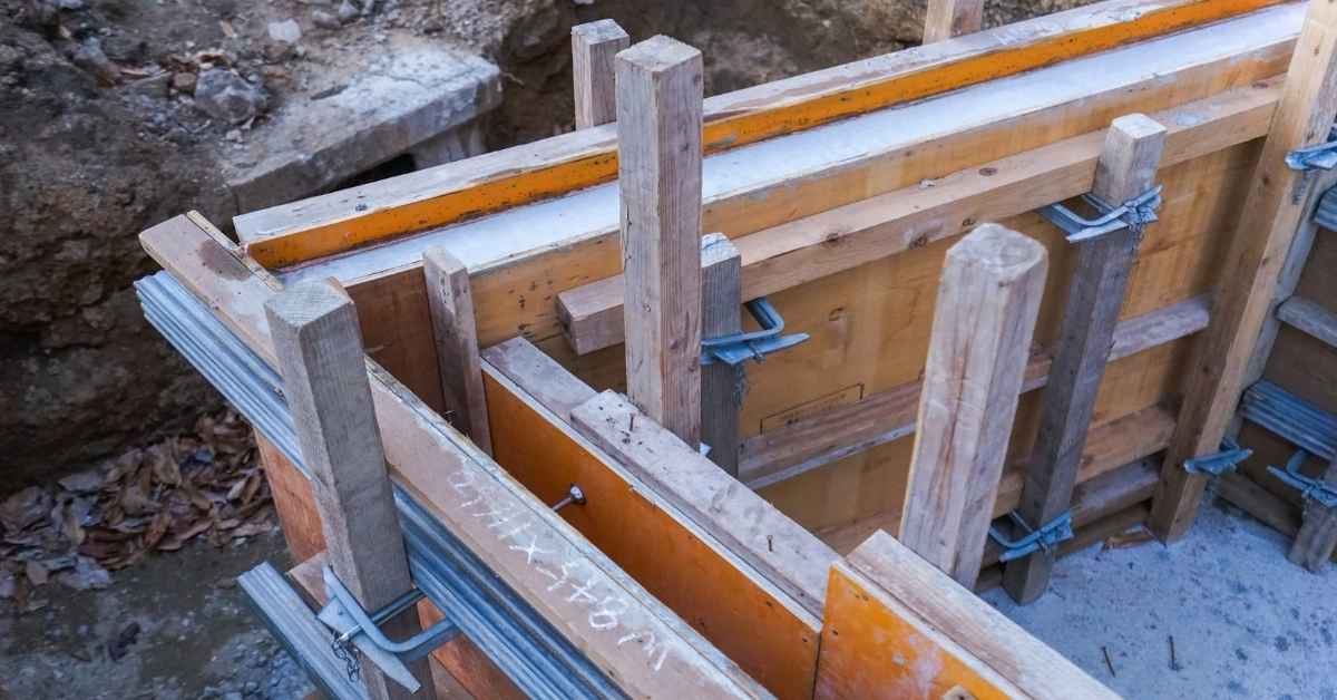 Wooden and metal braces supporting concrete formwork panels outdoors