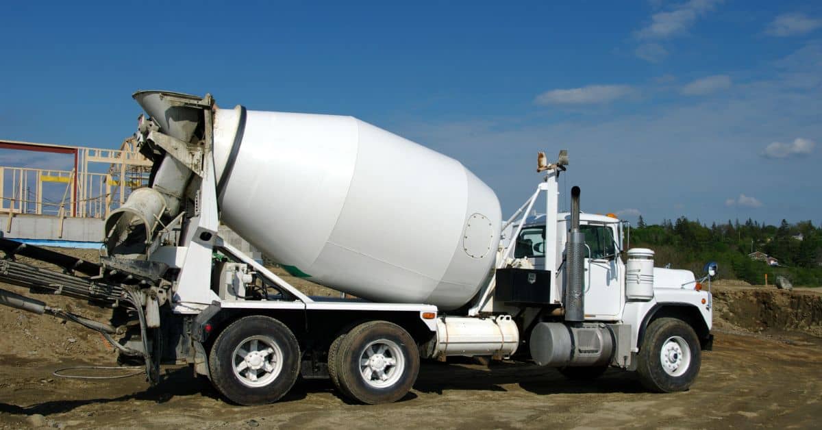 White concrete mixer truck parked on construction site