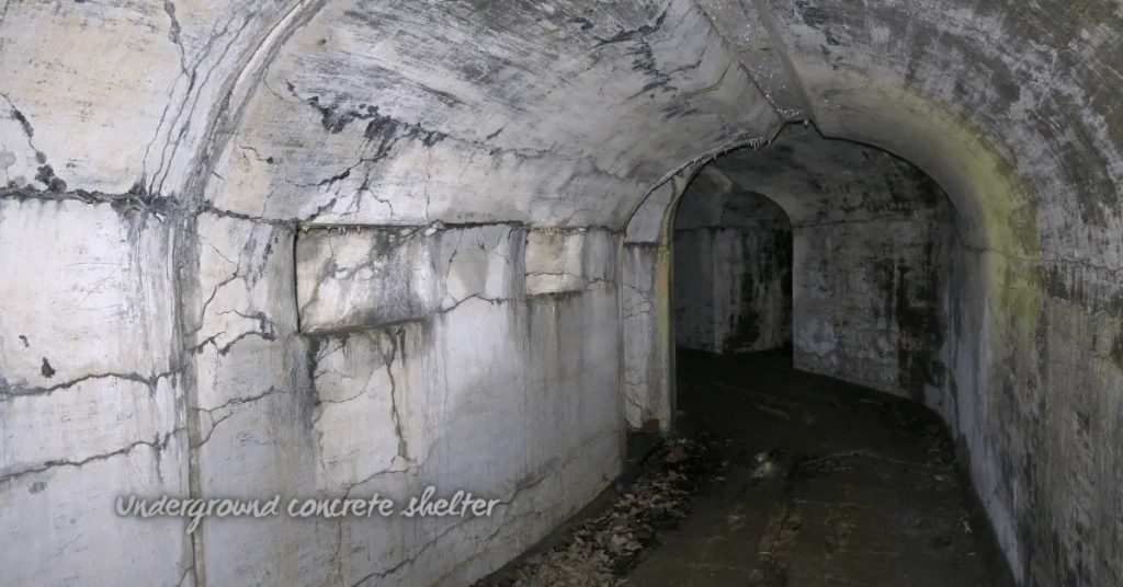 Cracked concrete walls and ceiling inside underground tunnel