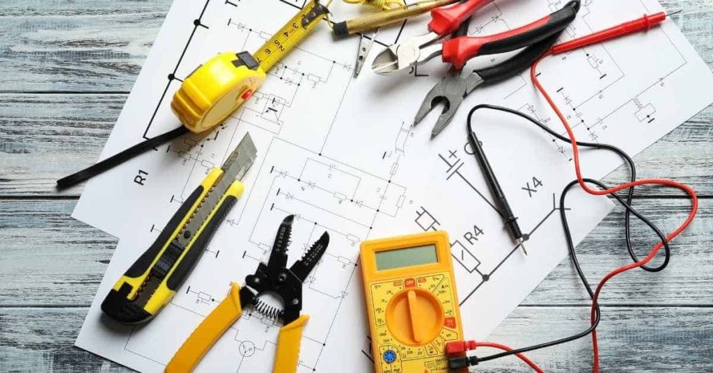 Electrical tools and measuring tape on circuit blueprint