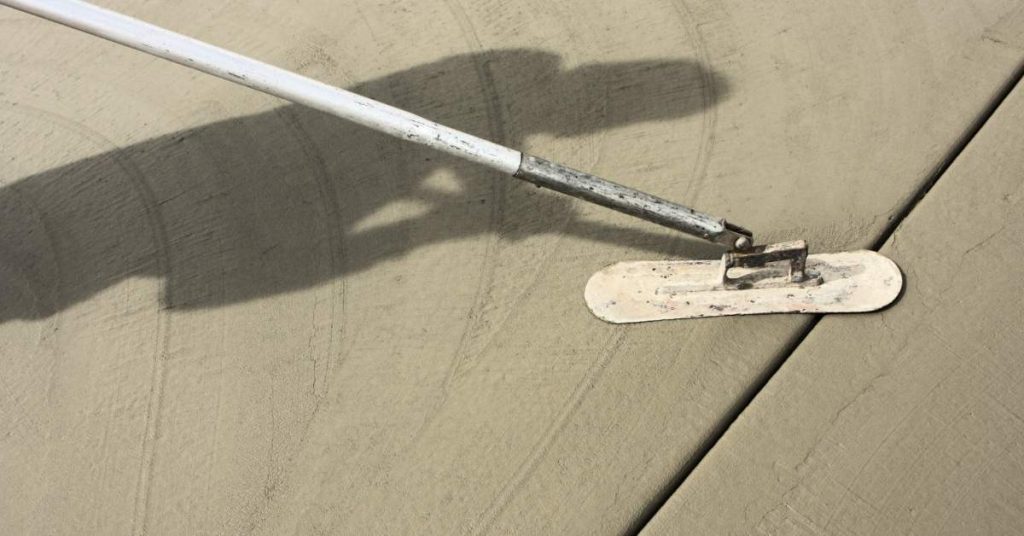 Handheld float smoothing fresh concrete slab surface