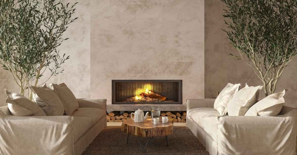 Living room with plastered beige walls and lit fireplace