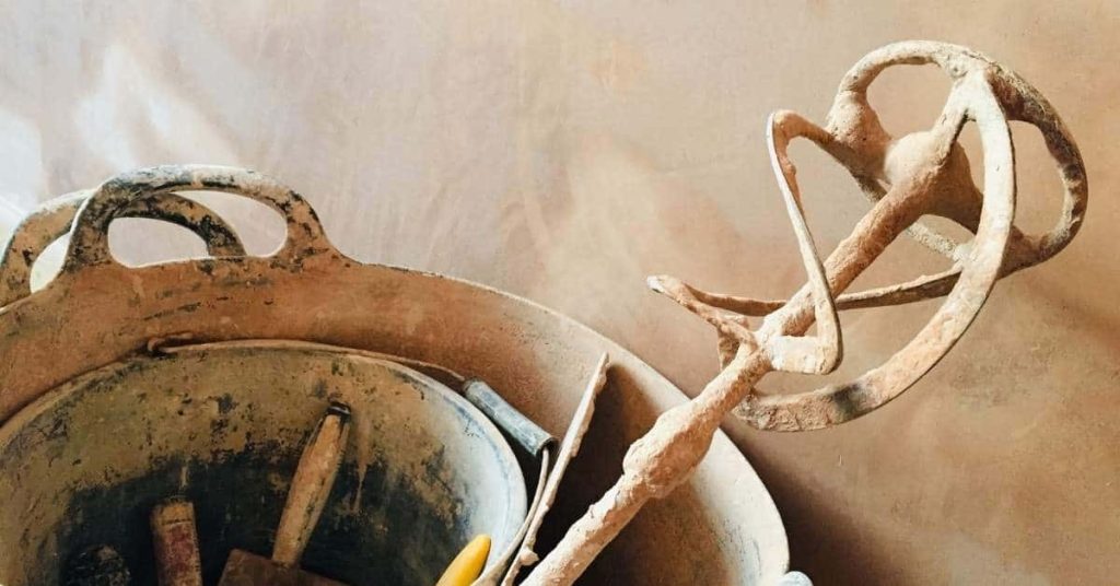 Old mixing bucket with mortar mixer tool inside