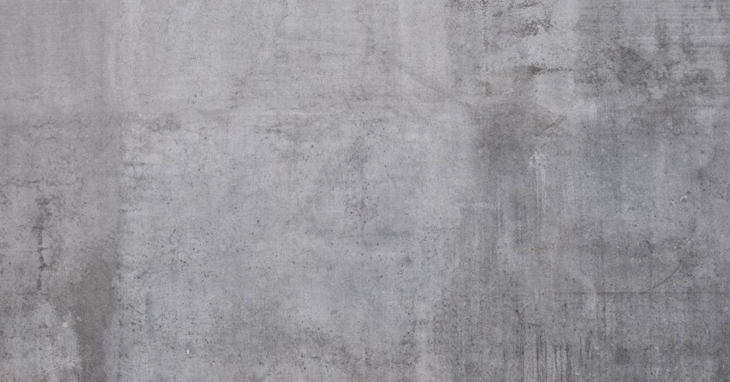 rough textured grey concrete wall surface with marks