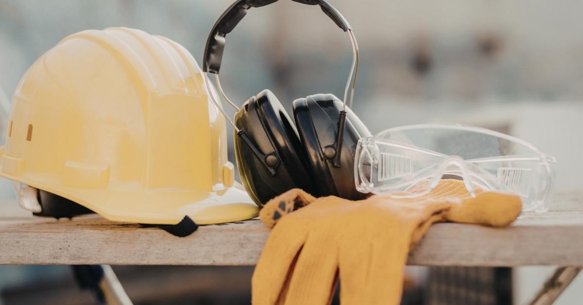 Yellow hard hat black ear protection clear safety glasses yellow gloves