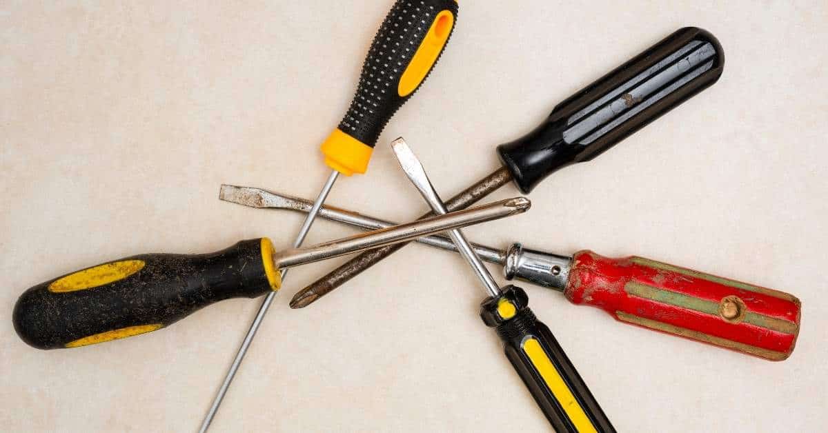 Five assorted old screwdrivers with different handles