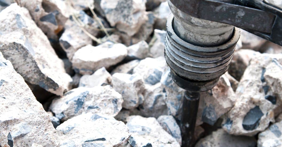 Close-up of jackhammer breaking concrete into chunks