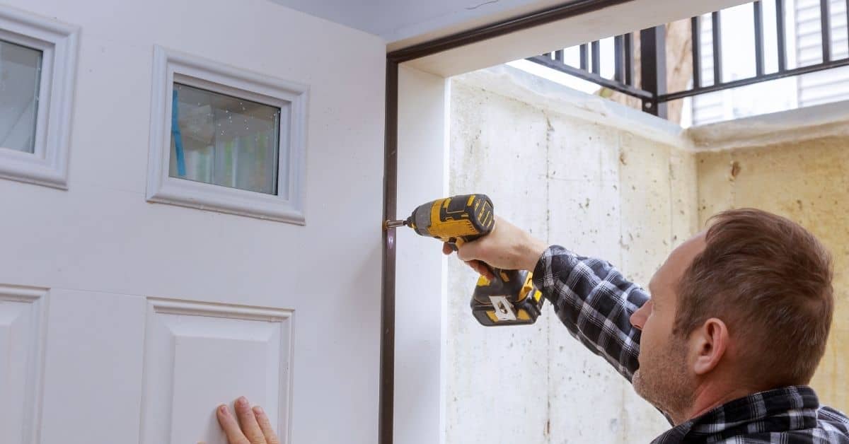 Man using power drill to install a door frame
