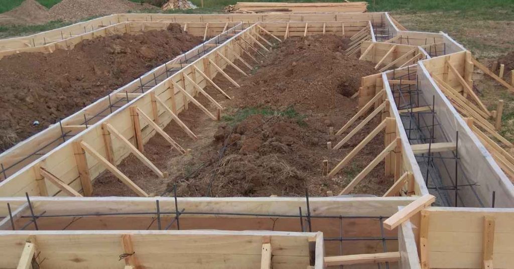 Foundation formwork with exposed reinforcing bars and diagonal wood braces before concrete placement