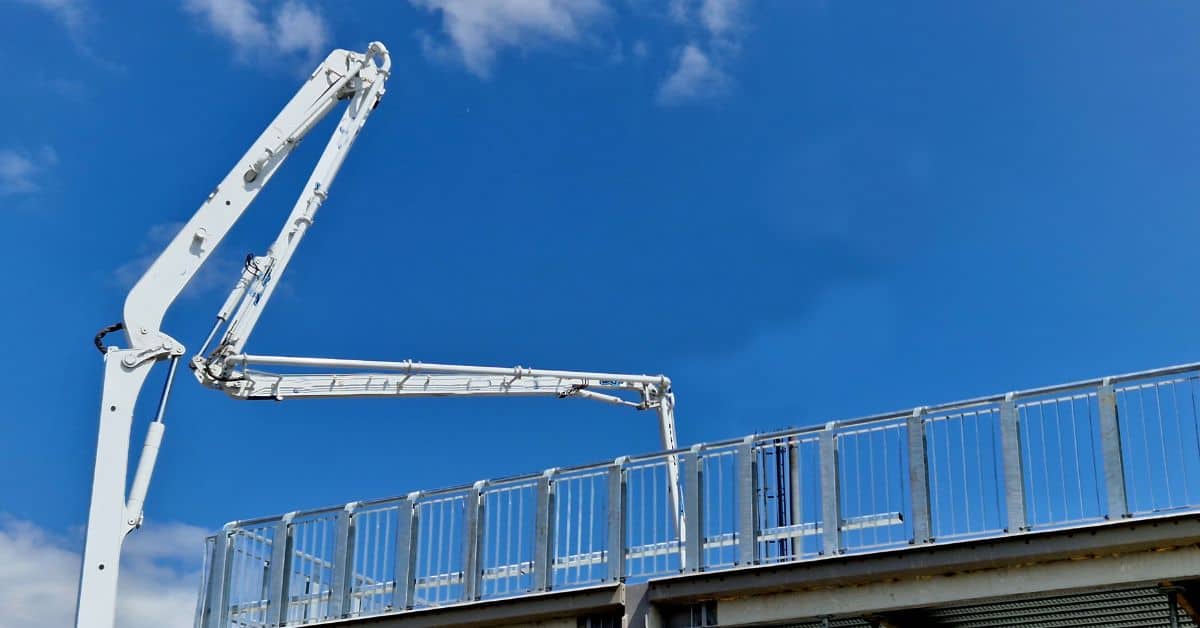 Concrete pump boom extending over an elevated building edge