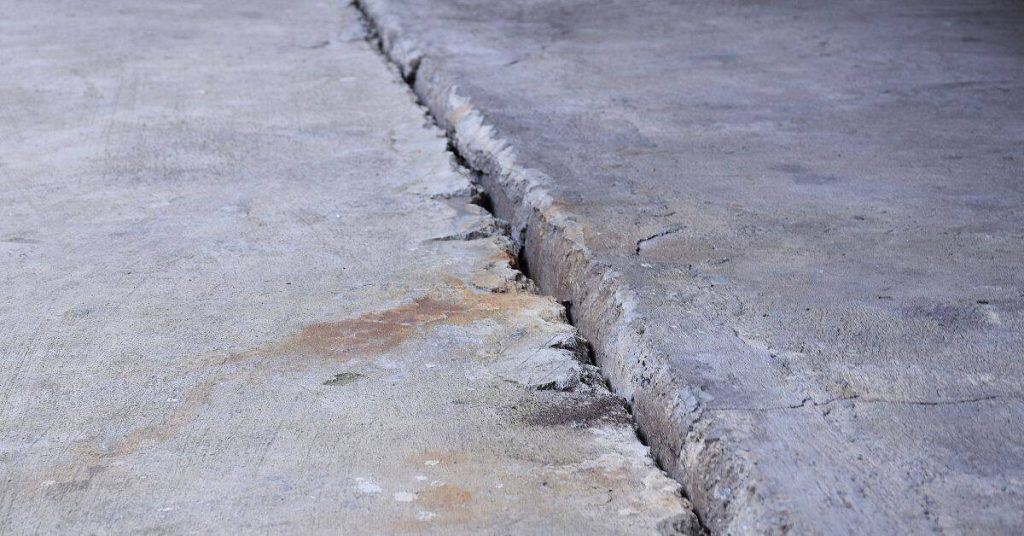 Wide cracked and uneven concrete slab with spalled edges