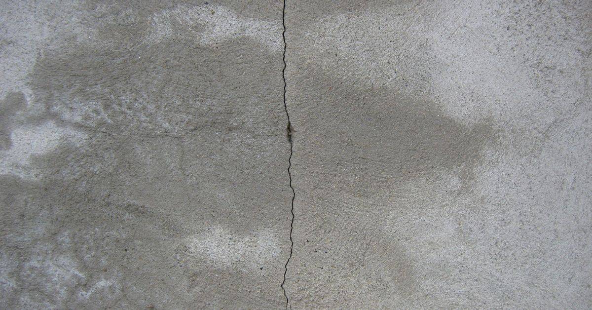 Close-up of a narrow vertical crack in a concrete surface