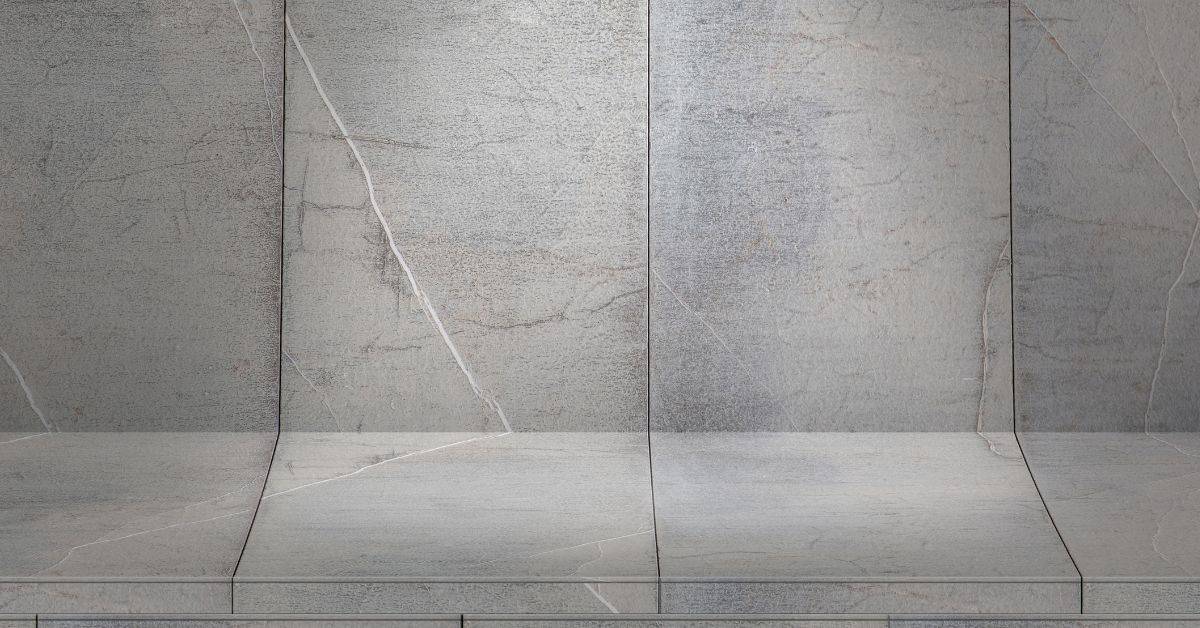 Cracks visible across gray concrete wall, floor, and corner surfaces